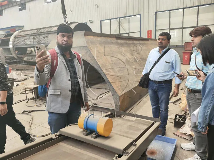 Des clients indiens visitent une machine de recyclage de bouteilles en plastique